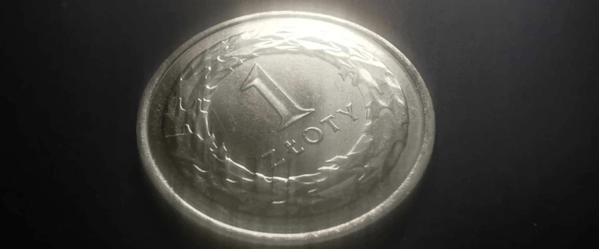 zdjęcie przedstawiające monetę 1 zł reszką do góry na czarnym tle