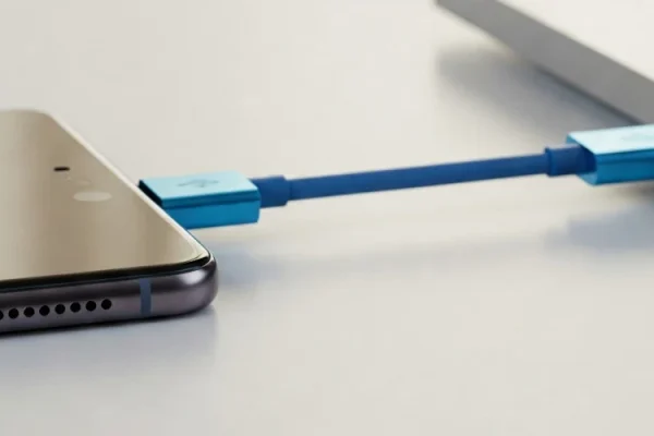 grafika przedstawiająca smartfona podłączonego do laptopa za pomocą kabla USB